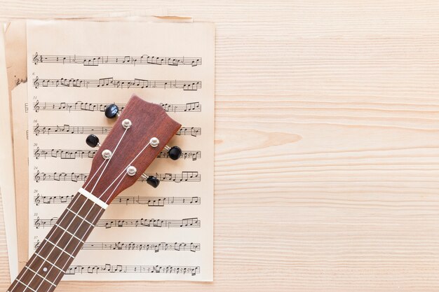 Vista dall'alto collo di chitarra con spartito musicale