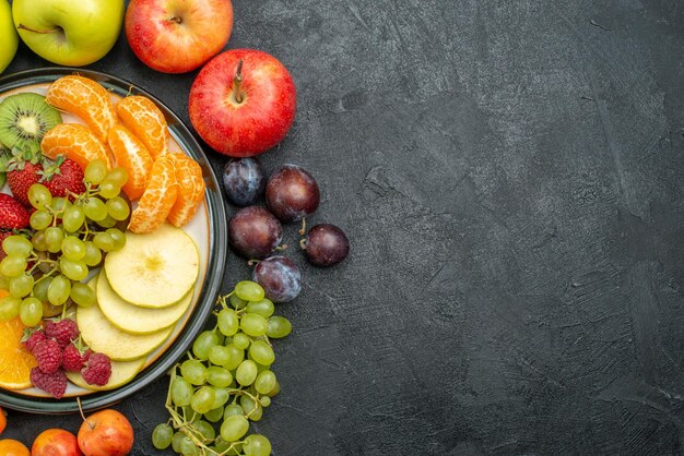 Vista dall'alto composizione di diversi frutti freschi e maturi sullo sfondo grigio frutti freschi dolci maturi per la salute