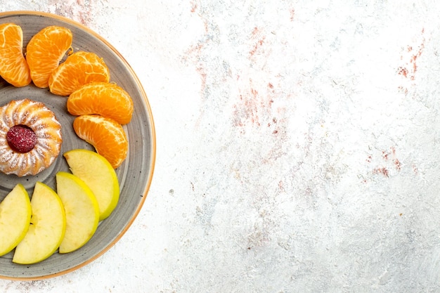 Vista dall'alto composizione di frutta diversa frutta fresca e affettata con torta su sfondo bianco chiaro frutti maturi morbidi colore salute