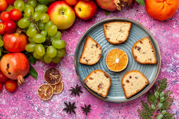 Vista dall'alto composizione di frutta fresca frutta colorata con torte a fette rosa scrivania