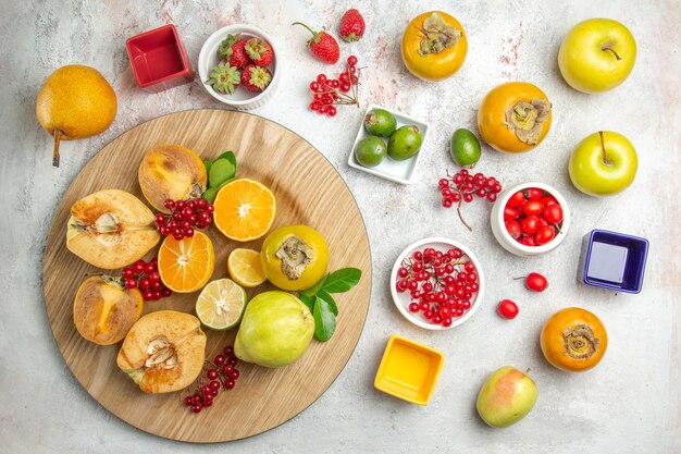 Vista dall'alto composizione nella frutta mele pere e altri frutti sulla tavola bianca frutta fresca matura