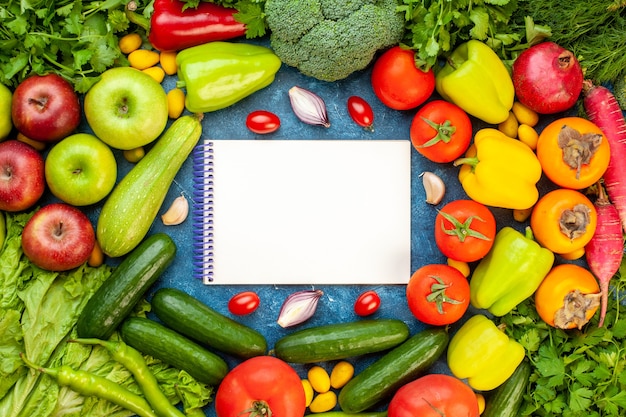 Vista dall'alto composizione vegetale con frutta fresca su scrivania blu colore insalata di dieta matura pasto di vita sana