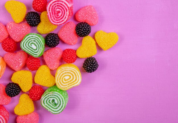 Vista dall'alto copia spazio marmellata multicolore in diverse forme su uno sfondo rosa chiaro