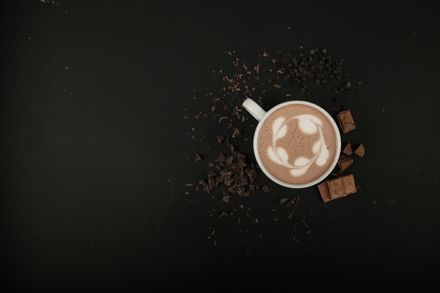 Vista dall'alto copia spazio tazza di cappuccino con cioccolato sul tavolo nero