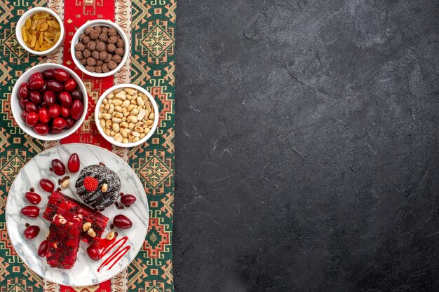 Vista dall'alto cornioli rossi con noci torrone e uvetta su sfondo grigio zucchero candito frutta dado dolce