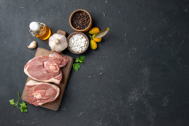 Vista dall'alto costolette di carne fresca carne cruda con condimenti su barbecue scuro piatto di animali pepe cibo insalata pasto cucina alimentare