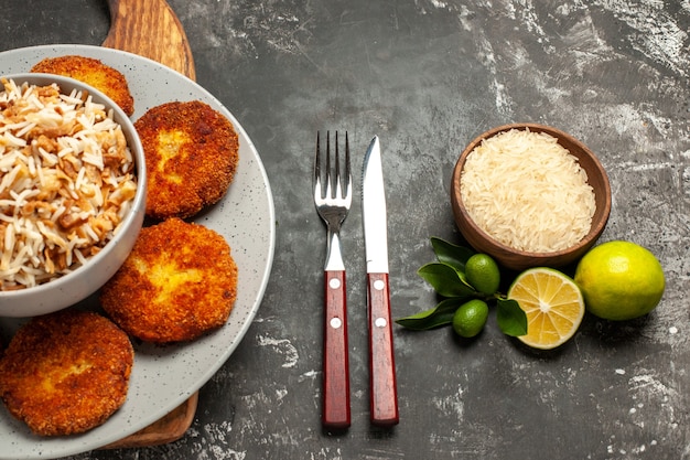 Vista dall'alto cotolette fritte con riso cotto su polpetta di carne piatto piano scuro