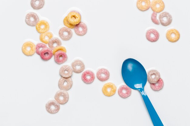 Vista dall'alto cucchiaio blu e anelli di frutta a base di cereali