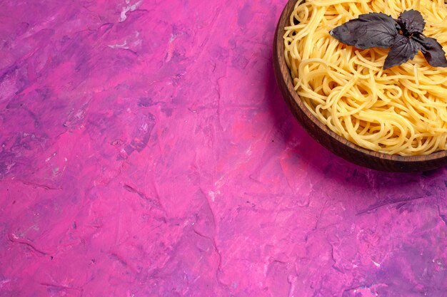 Vista dall'alto cucinati deliziosi spaghetti all'interno del piatto su pasta rosa da tavola