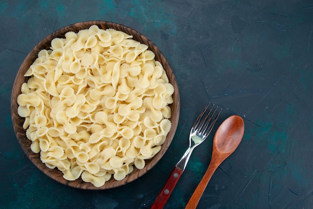 Vista dall'alto cucinato pasta italiana all'interno del piatto marrone su blu scuro
