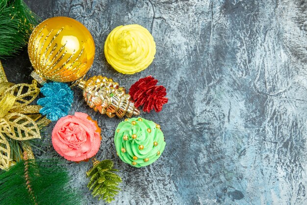 Vista dall'alto cupcakes colorati ornamenti di natale su sfondo grigio