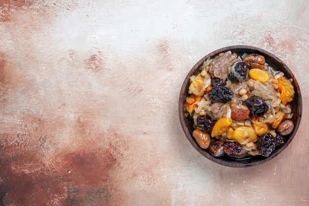 Vista dall'alto da lontano ciotola di pilaf di pilaf con frutta secca sul tavolo