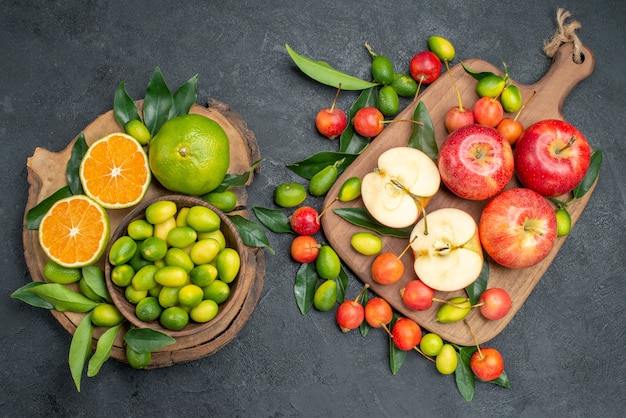 Vista dall'alto da lontano frutta mele sul tagliere ciliegie bordo con agrumi