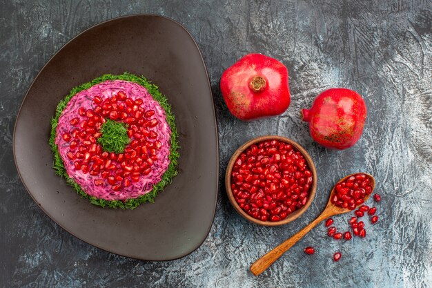 Vista dall'alto da lontano frutti un appetitoso piatto con erbe melograni semi di melograno cucchiaio