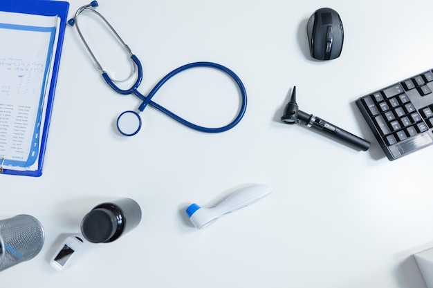 Vista dall'alto degli strumenti per esami medici in piedi sul tavolo in un moderno ufficio medico vuoto pronto per la consultazione sanitaria. Posto di lavoro ospedaliero attrezzato con strumenti professionali. Assistenza medica