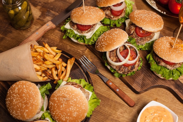 Vista dall'alto dei classici cheesburger accanto alle patatine fritte. Fast food. Carne di manzo alla griglia.