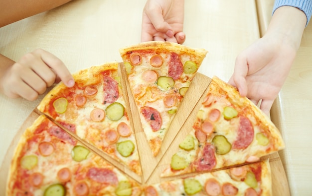 Vista dall&#39;alto dei ragazzi afferra una fetta di pizza