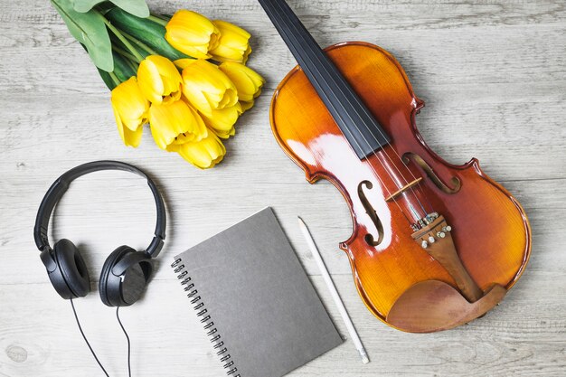 Vista dall&#39;alto dei tulipani; diario; matita e violino su fondo in legno