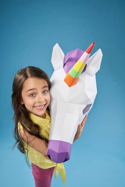 Vista dall'alto del bambino felice mantenendo unicorno di carta