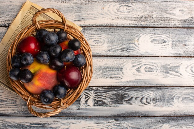 Vista dall'alto del cesto con frutta sul des di legno grigio