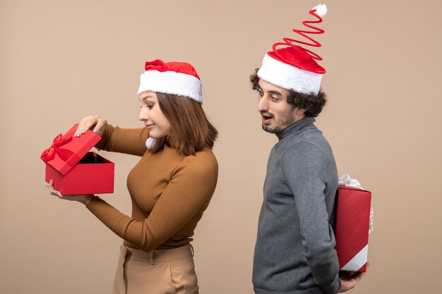 Vista dall'alto del concetto di umore e festa del nuovo anno - coppia adorabile sorpresa che tiene i regali che indossano Babbo Natale