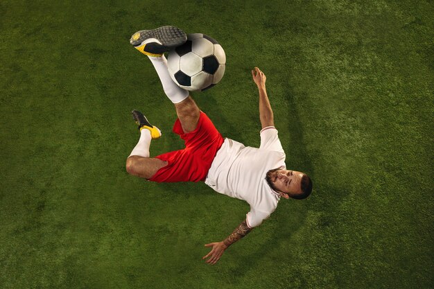 Vista dall'alto del giocatore di calcio o di calcio sull'erba verde