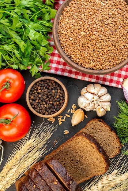 Vista dall'alto del grano saraceno di verdure fresche in una ciotola marrone su un asciugamano rosso spogliato punte di fette di pane verde