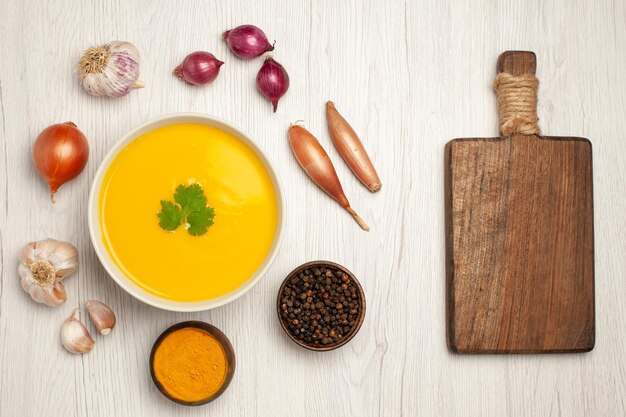 Vista dall'alto del gustoso piatto strutturato con crema di zuppa di zucca su bianco chiaro