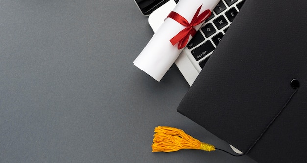 Vista dall'alto del laptop con diploma e cappello accademico