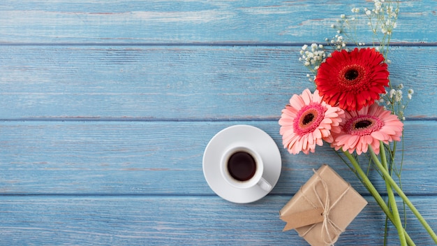 Vista dall'alto del mazzo di fiori con confezione regalo e tazza di caffè