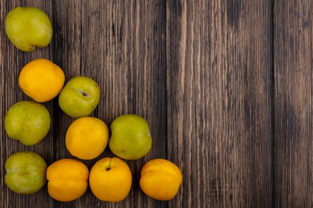 Vista dall'alto del modello di frutti come pluots e nectacots su sfondo di legno con copia spazio