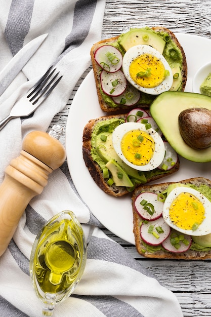 Vista dall'alto del piatto con uova e avocado panini e posate