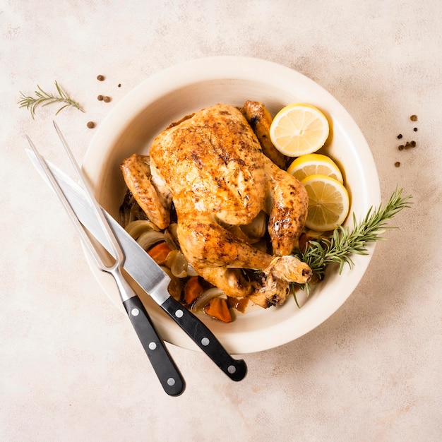 Vista dall'alto del pollo arrosto del ringraziamento con fette di limone e posate