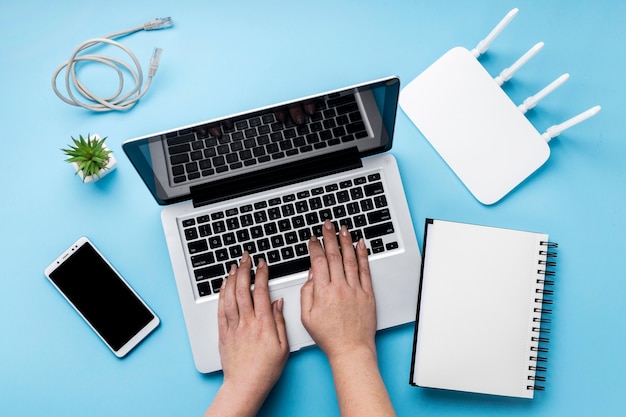 Vista dall'alto del router wi-fi con le mani utilizzando laptop e smartphone