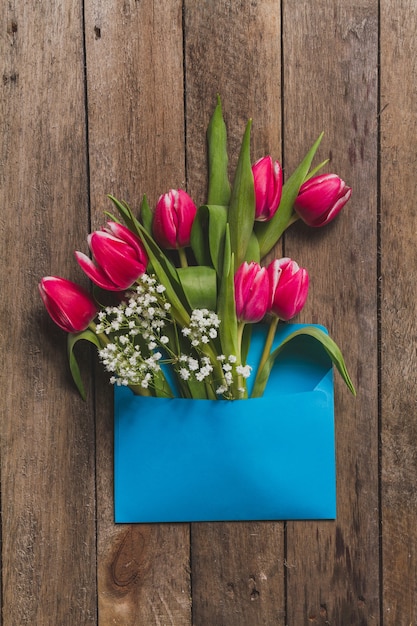 Vista dall&#39;alto del tavolo con i fiori fantastici e busta blu