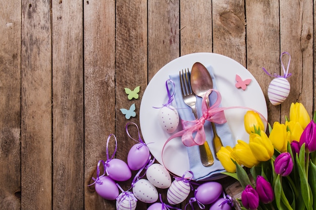 Vista dall&#39;alto del tavolo con uova di Pasqua e fiori decorativi