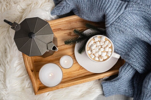 Vista dall'alto del vassoio con candele e tazza di cioccolata calda con marshmallow