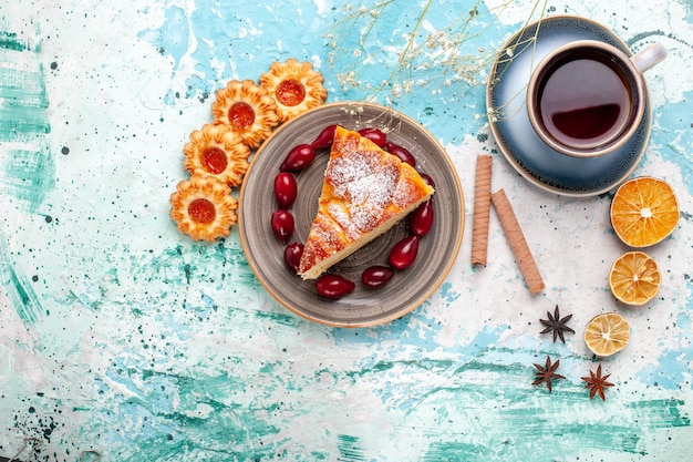 Vista dall'alto deliziosa fetta di torta con una tazza di tè sulla superficie blu torta cuocere al forno torta biscotto dolce