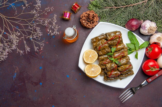 Vista dall'alto deliziosa foglia dolma con fette di limone sullo sfondo scuro piatto di carne foglia cena pasto cibo