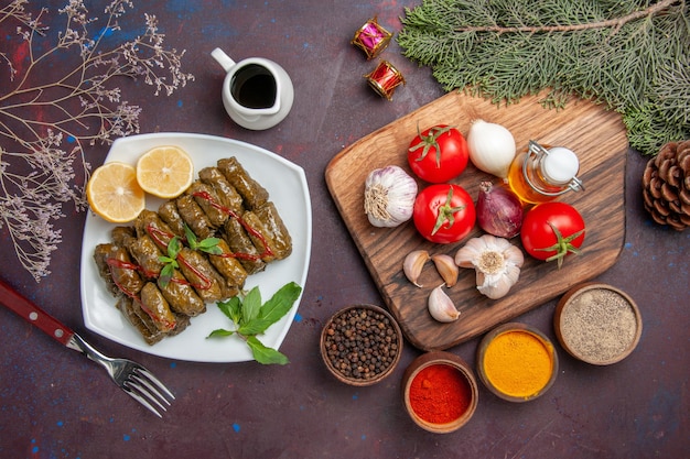 Vista dall'alto deliziosa foglia dolma con verdure fresche e condimenti sullo sfondo scuro pasto piatto foglia carne cena cibo