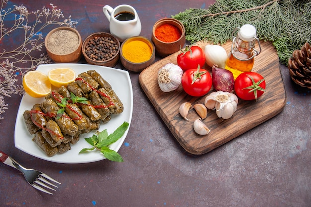 Vista dall'alto deliziosa foglia dolma con verdure fresche e condimenti sullo sfondo scuro pasto piatto foglia carne cena cibo