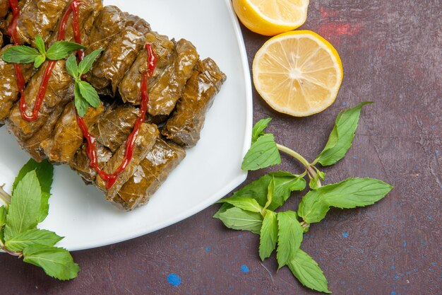 Vista dall'alto deliziosa foglia dolma piatto di carne macinata all'interno del piatto su sfondo scuro piatto foglia cena cibo carne