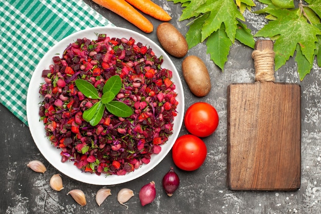 Vista dall'alto deliziosa insalata di barbabietole vinaigrette con verdure sulla superficie grigia