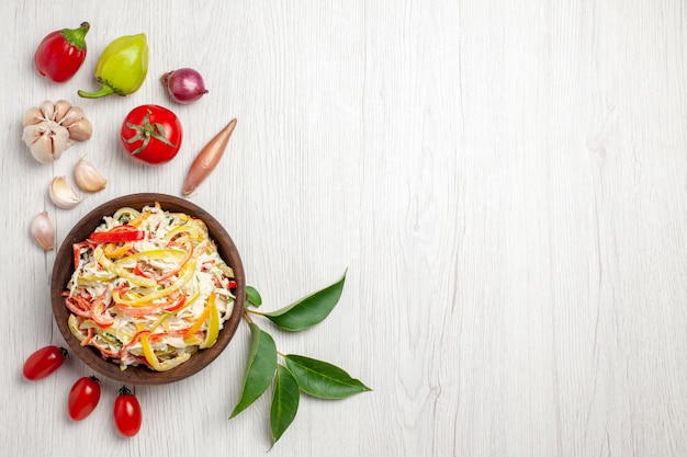 Vista dall'alto deliziosa insalata di pollo con maionese e verdure su spuntino da scrivania bianco insalata di farina di carne di colore maturo