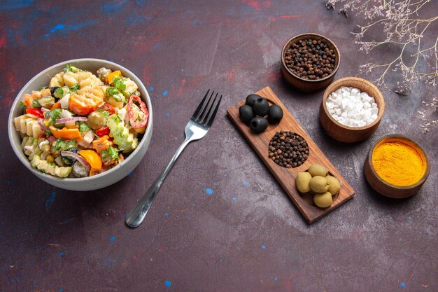 Vista dall'alto deliziosa insalata di verdure con diversi condimenti su sfondo scuro dieta di insalata di salute