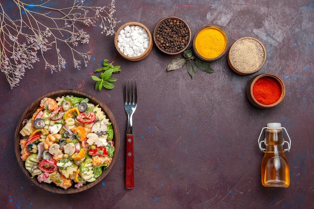 Vista dall'alto deliziosa insalata di verdure con diversi condimenti su sfondo viola scuro dieta salutare pranzo di insalata di verdure