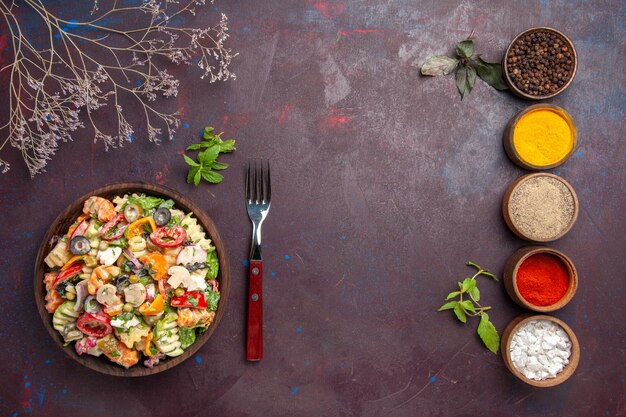 Vista dall'alto deliziosa insalata di verdure con diversi condimenti sul pranzo di insalata di verdure dieta salute piano scuro dark