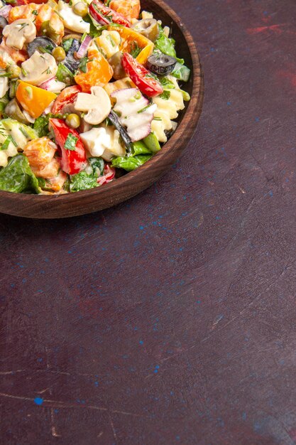 Vista dall'alto deliziosa insalata di verdure con pomodori, olive e funghi su sfondo scuro insalata salutare snack pranzo vegetale