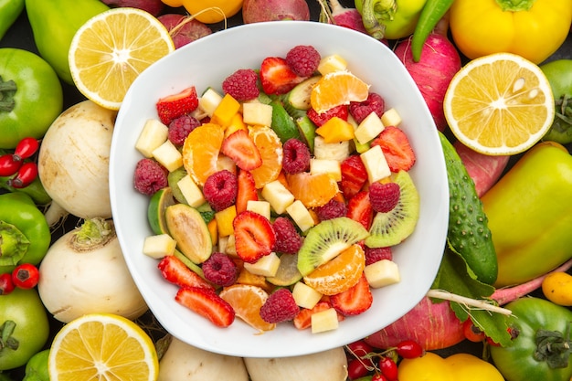 Vista dall'alto deliziosa macedonia di frutta all'interno del piatto con frutta fresca su albero da frutto grigio foto tropicale esotica dieta matura