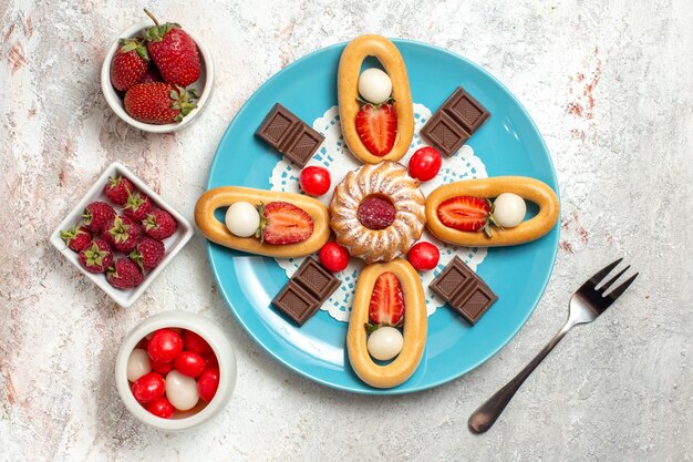 Vista dall'alto deliziosa piccola torta con barrette di cioccolato e cracker dolci su sfondo bianco cracker dolce torta biscotto torta tè